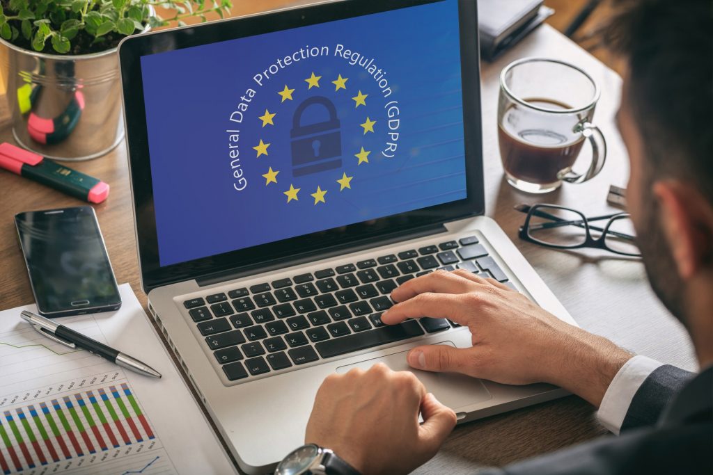Man working with a computer, General Data Protection Regulation and European Union flag